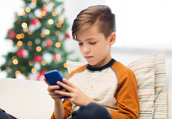 Image showing boy with smartphone at home at christmas