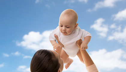 Image showing happy mother playing with little baby boy over sky