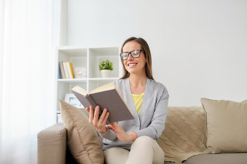 Image showing happy woman in glasses reading book at home