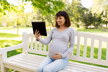 Image showing happy pregnant asian woman with tablet pc at park