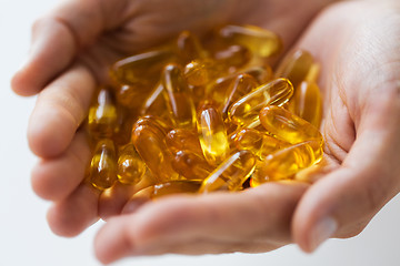 Image showing hands holding cod liver oil capsules