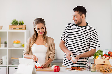 Image showing happy couple cooking food at home kitchen