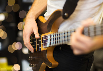 Image showing close up of musician with guitar at music studio