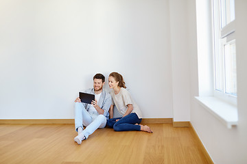 Image showing happy couple with tablet pc computer at new home