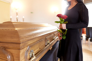 Image showing woman with red roses and coffin at funeral