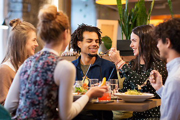 Image showing happy friends eating at restaurant