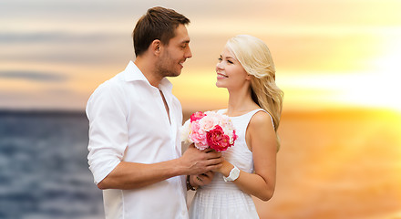 Image showing happy couple with flowers over sea background