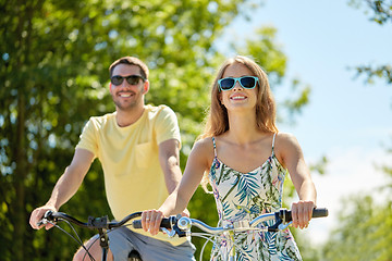 Image showing happy young couple riding bicycles in summer