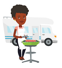 Image showing Woman having barbecue in front of camper van.