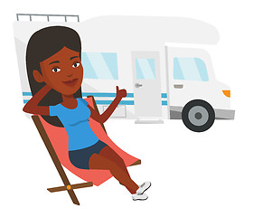 Image showing Woman sitting in chair in front of camper van.