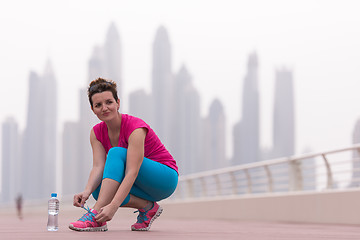 Image showing woman tying shoelaces on sneakers