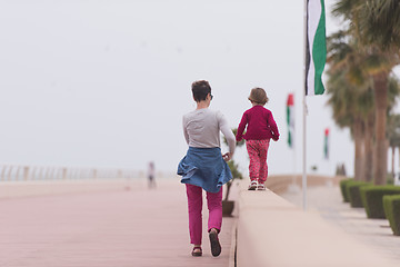 Image showing mother and cute little girl on the promenade by the sea