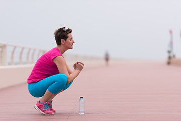 Image showing woman stretching and warming up on the promenade