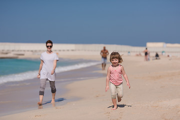 Image showing mother and daughter running on the beach