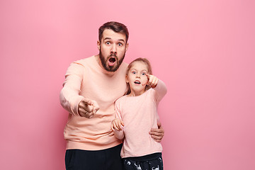 Image showing Surprised young family looking at camera on pink