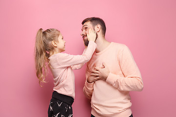 Image showing Young father with his baby daughter. The kid in preschool age pointing with finger