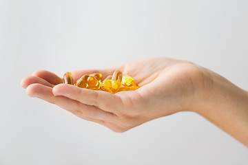 Image showing hand holding cod liver oil capsules