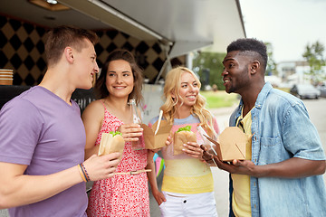 Image showing happy friends with drinks eating at food truck