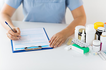 Image showing doctor with medicines and clipboard at hospital