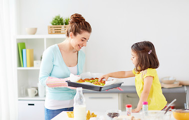 Image showing mother and daughter baking muffins at home