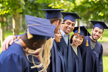 Image showing happy students or bachelors in mortar boards