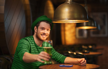 Image showing smiling man drinking green beer at bar or pub