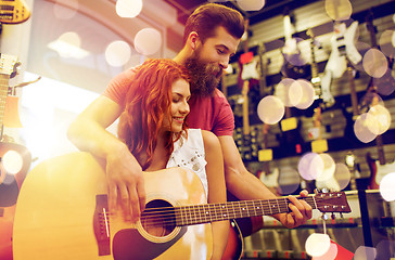 Image showing couple of musicians with guitar at music store