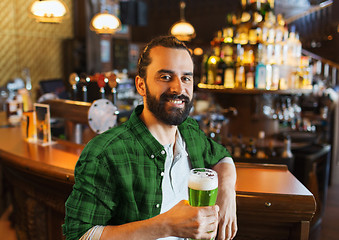 Image showing happy man drinking green beer at bar or pub