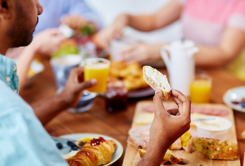 Image showing close up of man eating toast with cream cheese