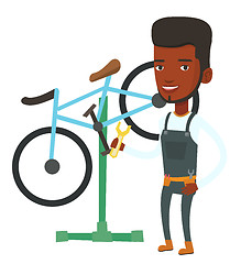 Image showing African bicycle mechanic working in repair shop.
