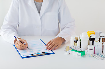 Image showing doctor with medicines and clipboard at hospital