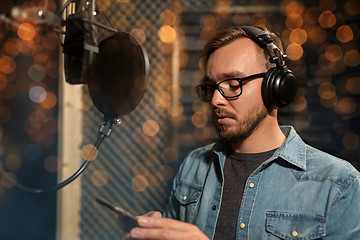 Image showing singer with headphones at music recording studio