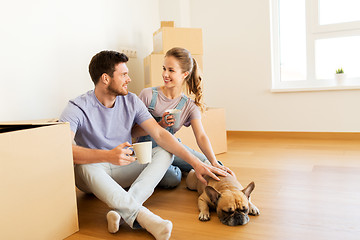 Image showing happy couple with boxes and dog moving to new home