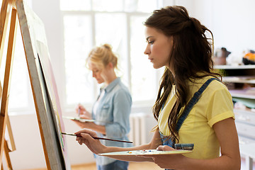 Image showing woman with easel painting at art school studio