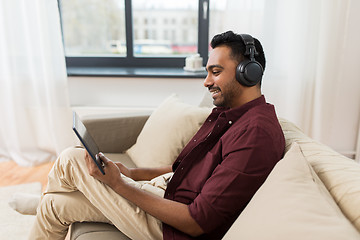Image showing man in phones with tablet pc listening to music