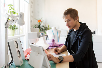 Image showing fashion designer with tablet pc working at studio