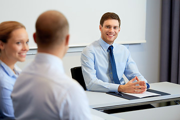 Image showing happy coworkers meeting and talking at office