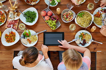 Image showing women with tablet pc at table full of food