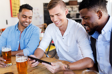 Image showing male friends with tablet pc drinking beer at bar