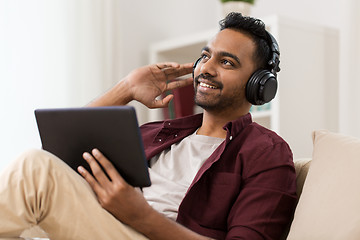 Image showing man in phones with tablet pc listening to music