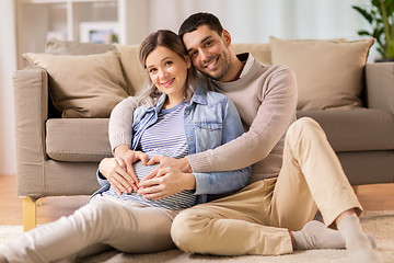 Image showing man with pregnant woman making hand heart at home