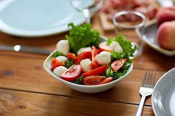 Image showing vegetable salad with mozzarella on wooden table