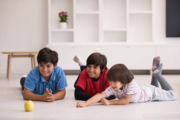 Image showing boys having fun with an apple on the floor