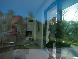 Image showing woman drinking coffee in front of her luxury home villa