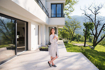 Image showing woman in a bathrobe enjoying morning coffee