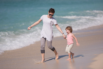 Image showing mother and daughter running on the beach