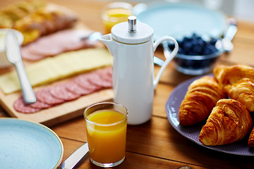 Image showing coffee pot, juice and food on table at breakfast