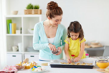 Image showing happy mother and daughter making cookies at home