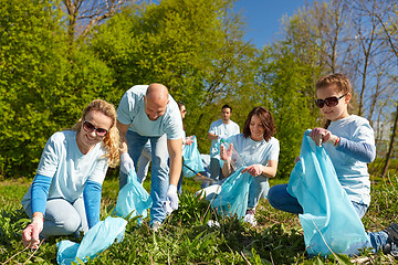 Image showing volunteers with garbage bags cleaning park area