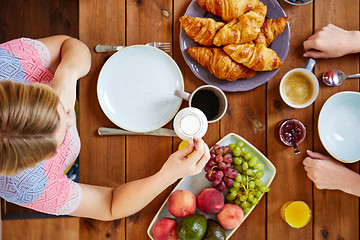 Image showing woman with cream and coffee having breakfast